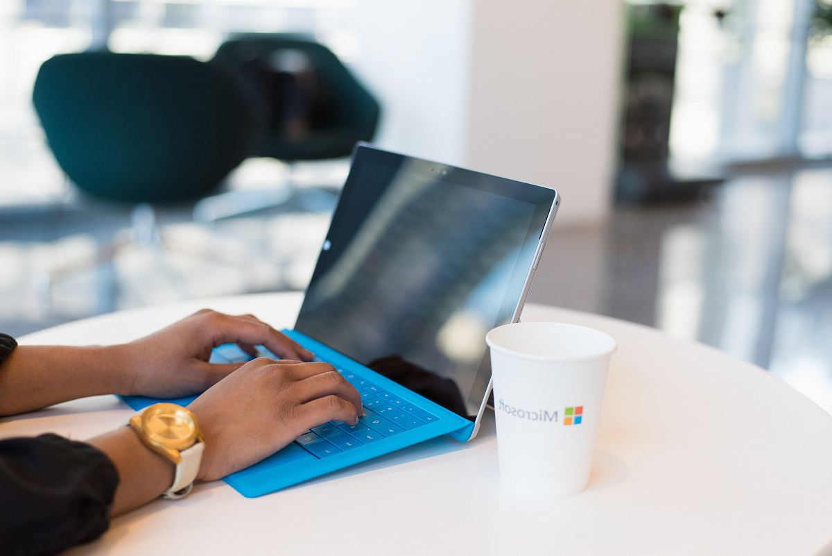 person using blue Microsoft Surface
